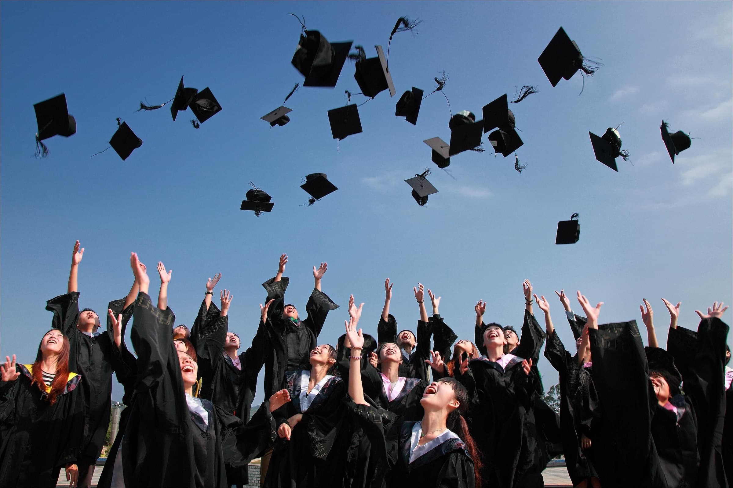 Asian university graduates celebrating on campus after studying in Australia, the study pathway Hays maps from Malaysia